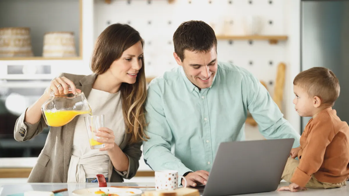 Gezin aan het keukenblok met een open laptop, waar een Duitse gast jouw boekingssite opent