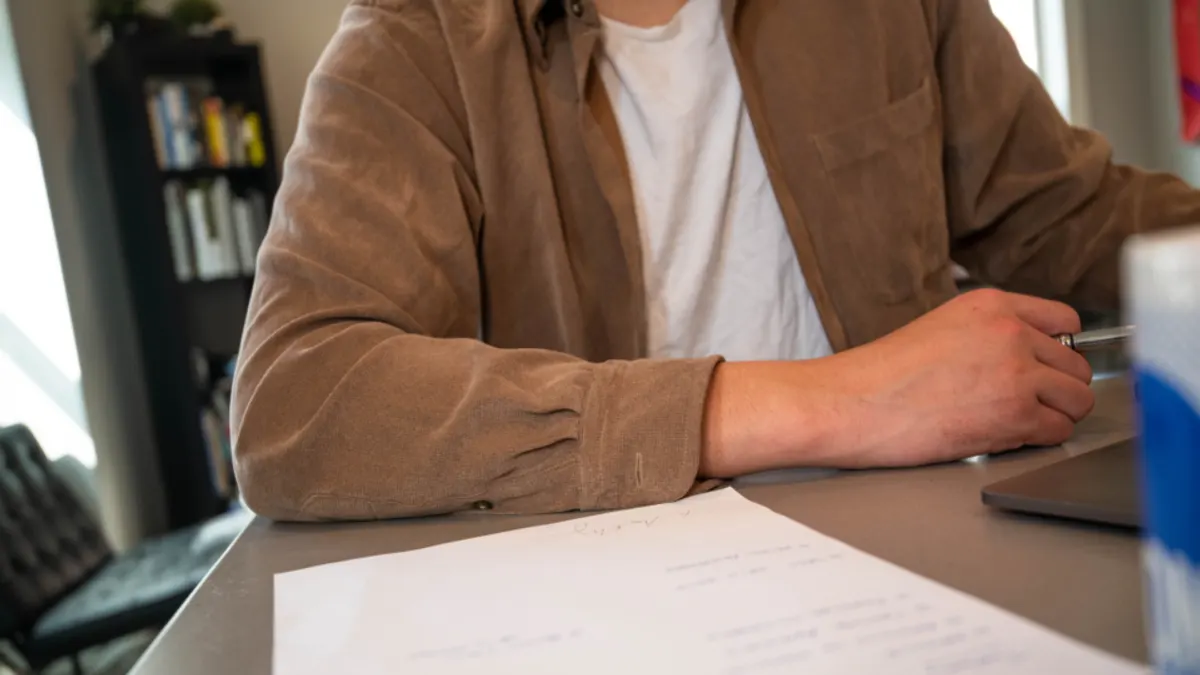Verhuurder met pen en papieren formulier aan een bureau voor de btw-aangifte