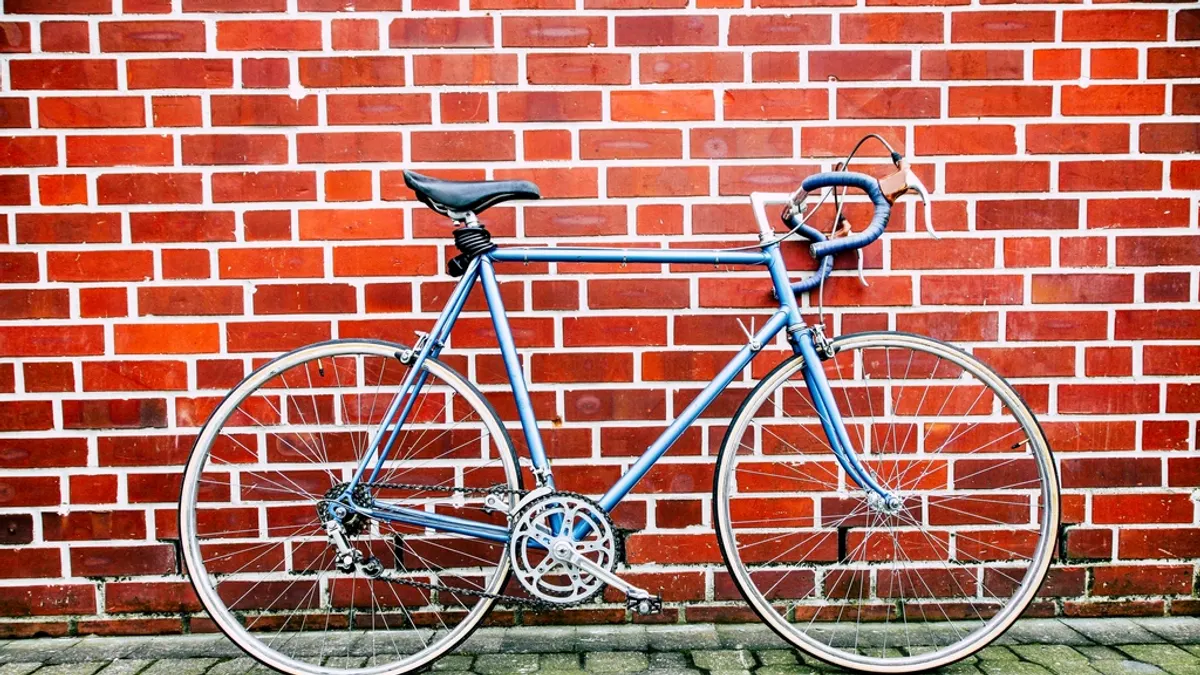 Fiets tegen een bakstenen muur klaar om te verhuren bij een vakantiehuis