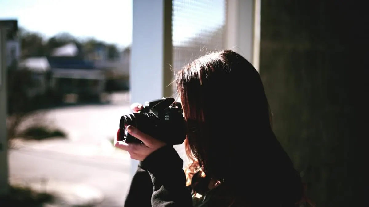 Vrouw fotografeert met een spiegelreflexcamera in de deuropening, zoals je elke ruimte bij daglicht vastlegt