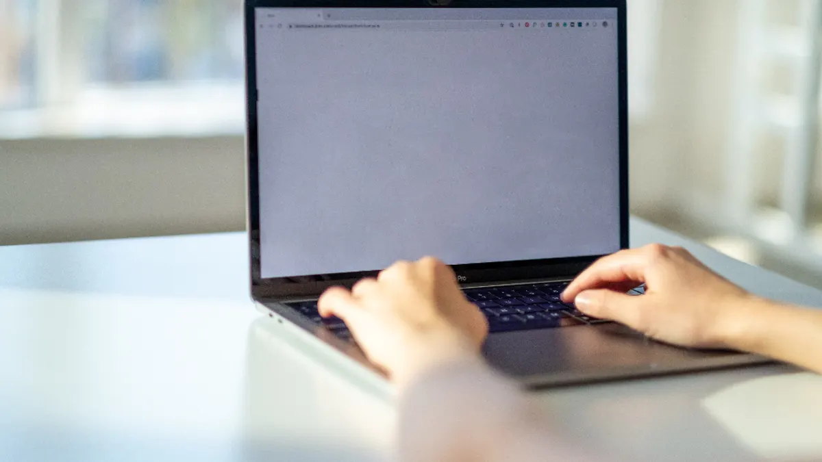 Handen typen een zoekterm in de browser om een vakantiehuis te vinden
