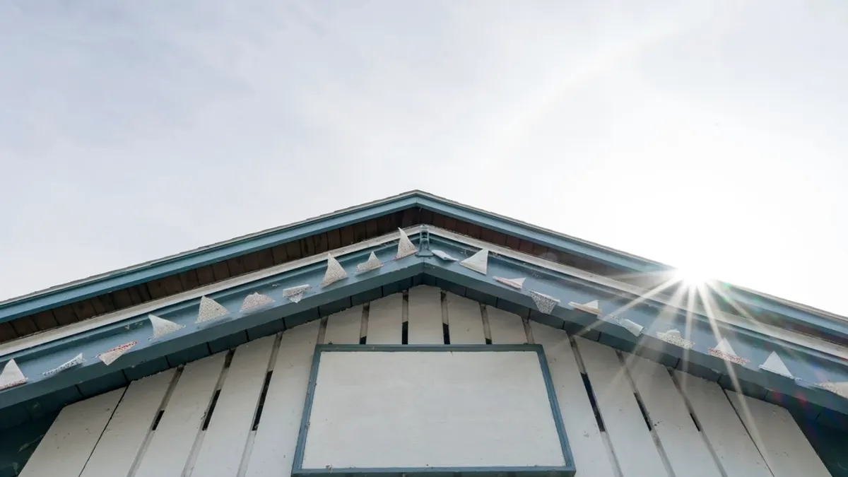 Leeg bord aan de houten gevel van een vakantiehuis, plek voor huisregels