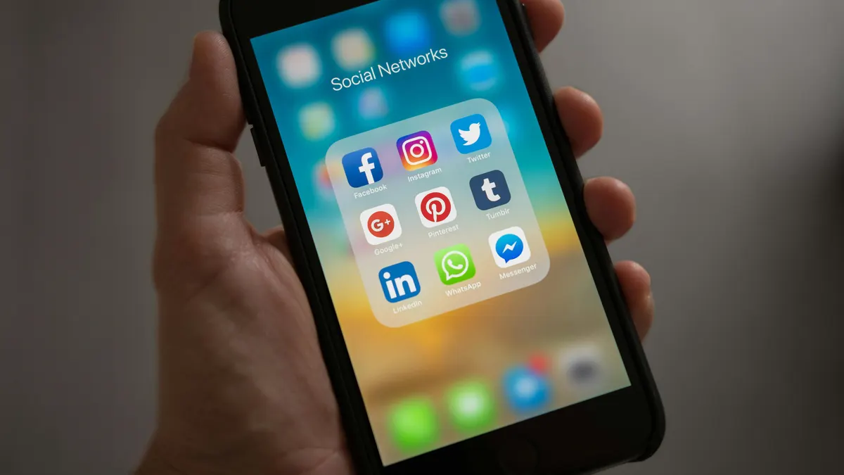 Hand houdt telefoon vast met de apps Instagram en Facebook voor vakantieverhuur