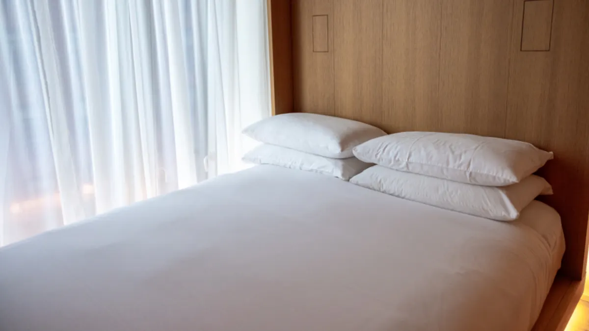 Opgemaakt bed met schoon wit beddengoed klaar voor de volgende boeking