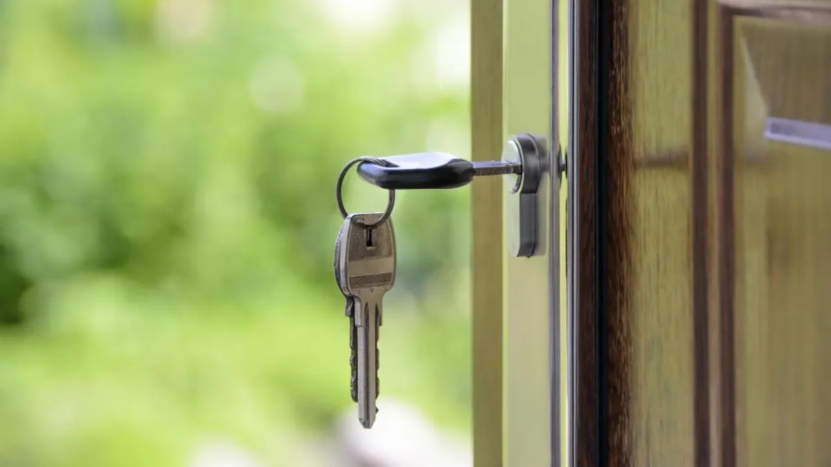 Sleutelbos in het slot van de geopende voordeur van een vakantiehuis