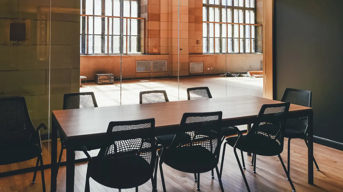 Lege vergaderzaal met lange tafel en stoelen, te verhuren per dagdeel